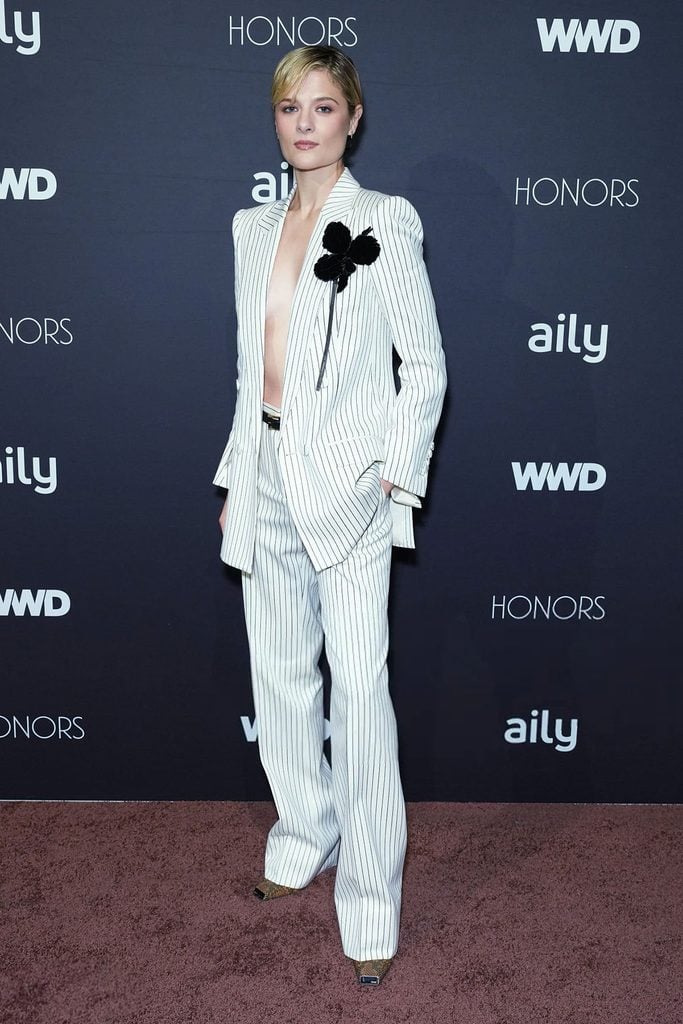 Louisa Jacobson wears a white pinstripe Tom Ford suit with black floral embellishment at the 2026 WWD Honors in New York.