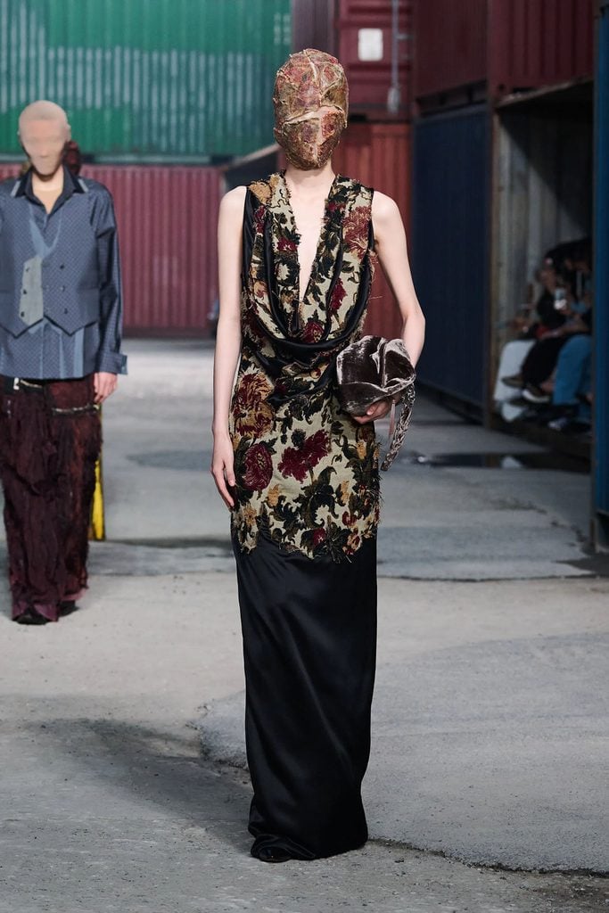 Maison Margiela Fall 2026 runway model wearing the tapestry-appliquéd draped dress later seen on Rebecca Hall at The Gilded Age premiere.