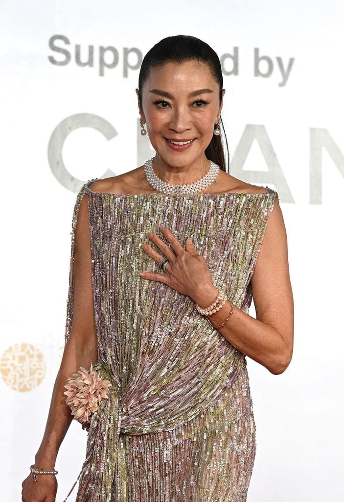 Michelle Yeoh wearing an embroidered pink-and-gold Dior Resort 2027 dress at the Busan International Film Festival opening ceremony with pearl jewels.