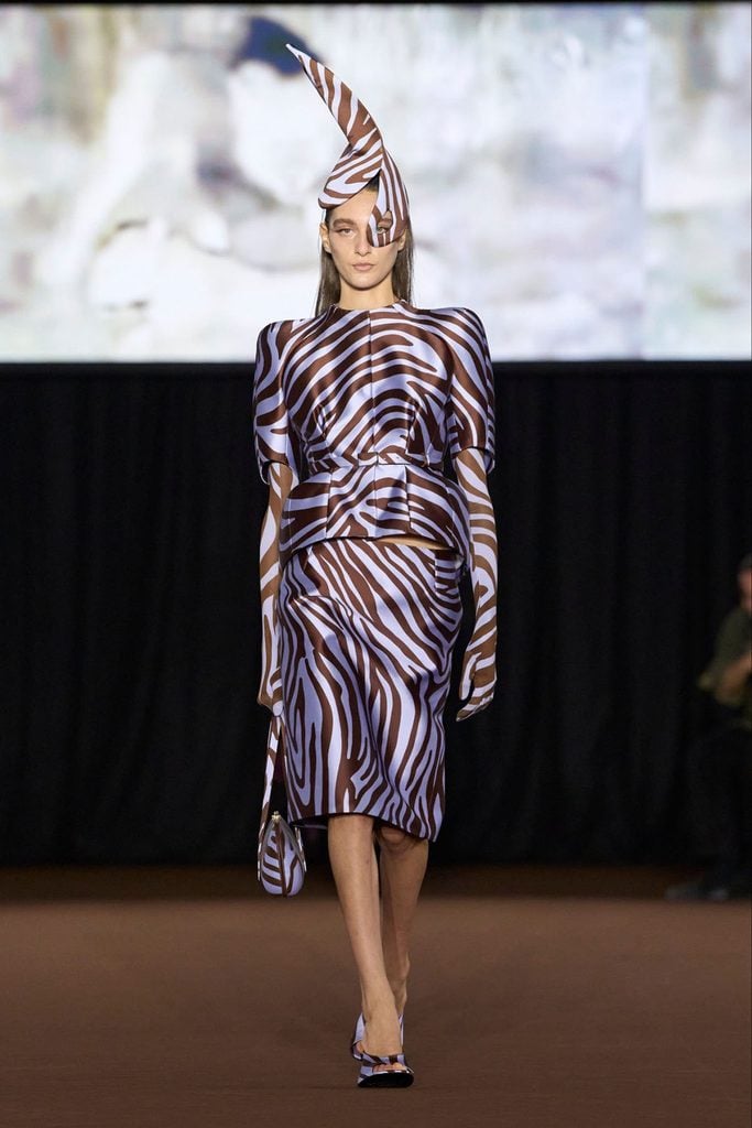 Mugler Spring 2027 runway model wearing the brown-and-lilac zebra-print jacket, skirt and dramatic sculptural headpiece later worn by Jodie Turner-Smith