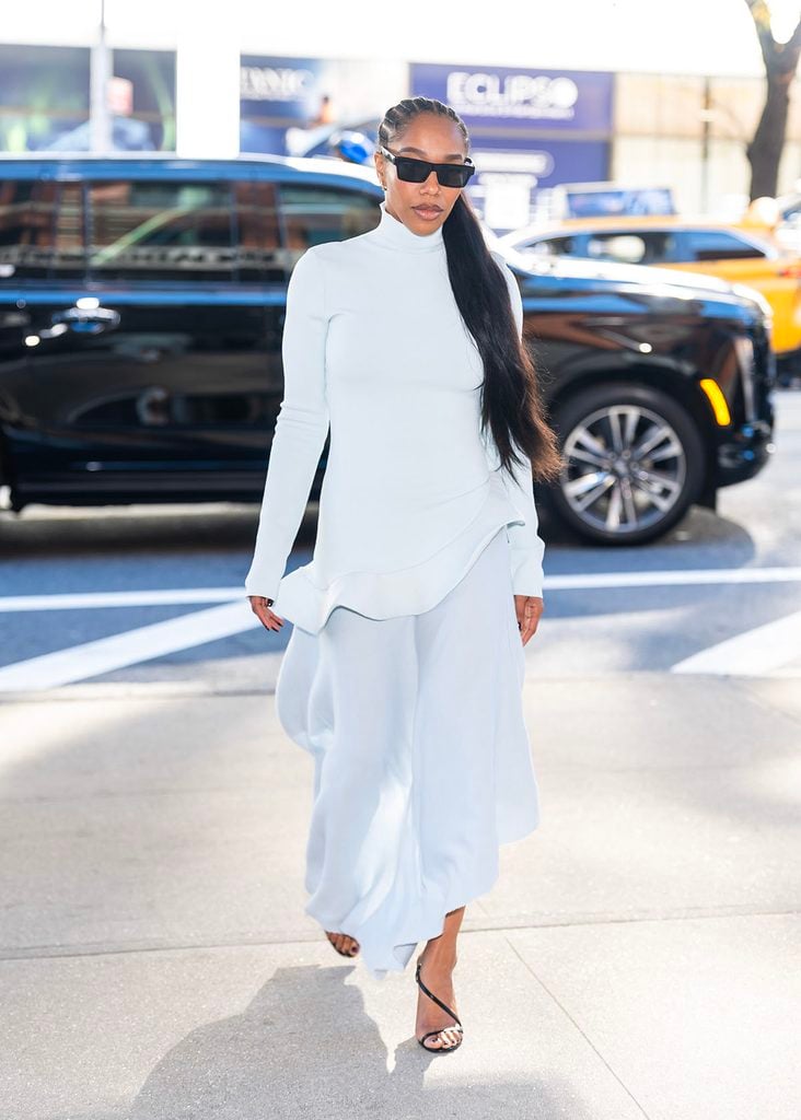 Naomi Ackie wears a pale blue Diotima Spring 2027 ensemble with a sculpted hem, sunglasses and a long ponytail during the Clayface press junket.