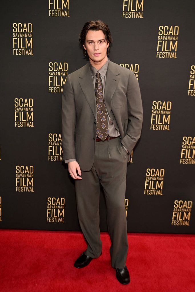 Nicholas Galitzine wears a dark moss P. Johnson suit with an olive shirt and patterned silk tie at the 2026 SCAD Savannah Film Festival.