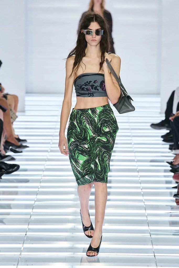 Model wearing a printed bandeau top and green patterned skirt on the Prada Spring 2027 runway.