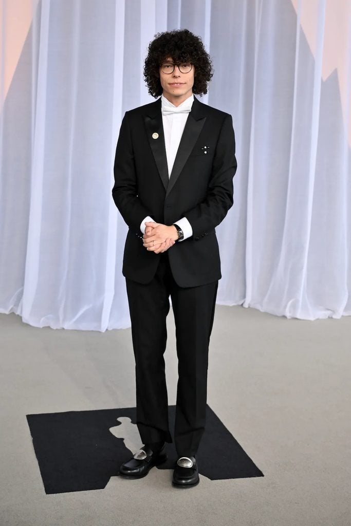 Reece Feldman wearing Dior black-tie tailoring with a white bow tie and decorative loafers at the Academy Museum Gala in Los Angeles.