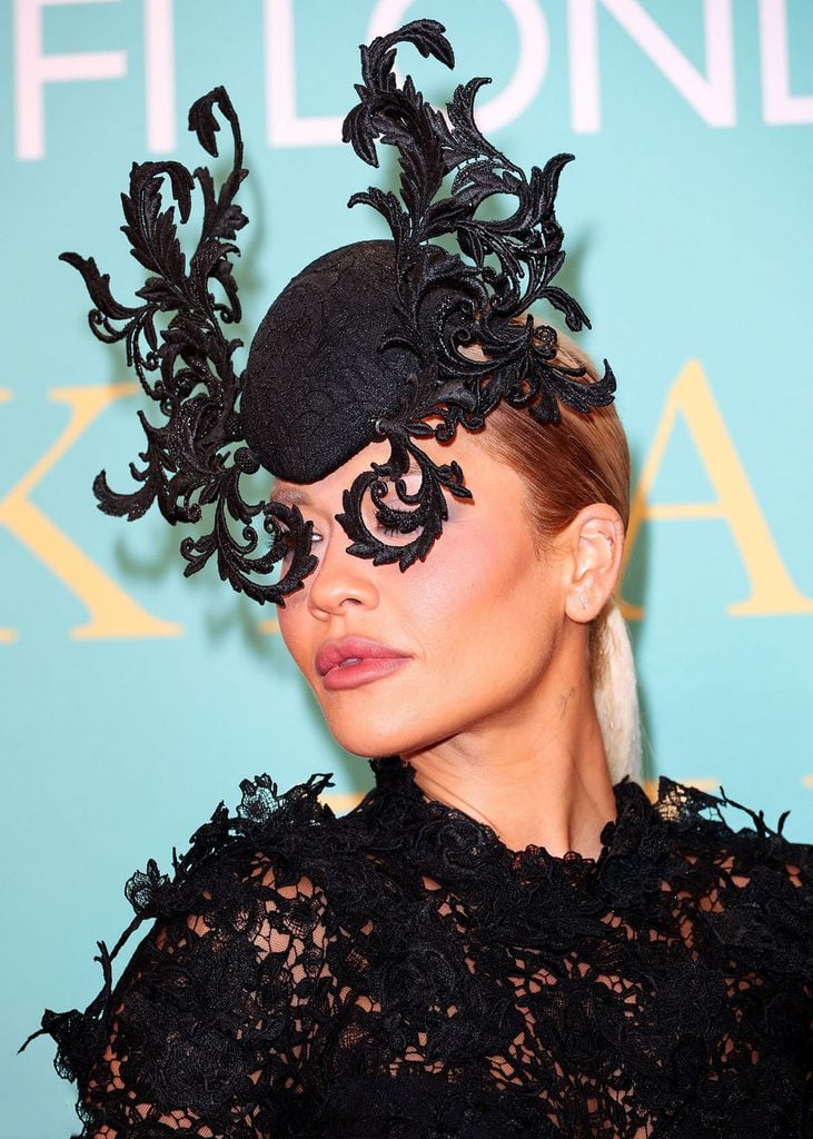 Close-up of Rita Ora's elaborate black Philip Treacy Fall 2017 headpiece with swirling lace details at the BFI London Film Festival