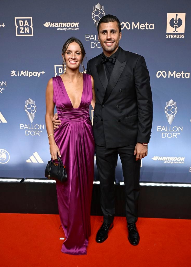 Rodri in a black Dolce & Gabbana double-breasted suit alongside Laura Iglesias in a purple gown at the 2026 Ballon d'Or Awards.