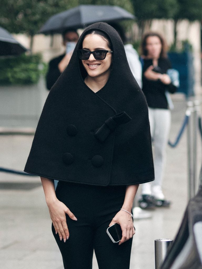 Rosalía in a Vaquera hooded cape and black sunglasses during Paris Fashion Week.