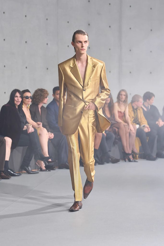 Model wearing a metallic gold single-breasted suit from Saint Laurent Spring 2027 menswear on the Paris runway.
