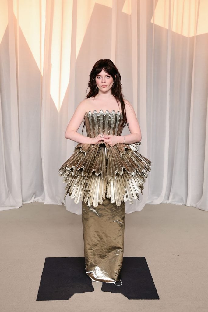 Sophie Thatcher wearing a sculptural gold lamé Louis Vuitton bustier gown at the 2026 Academy Museum Gala