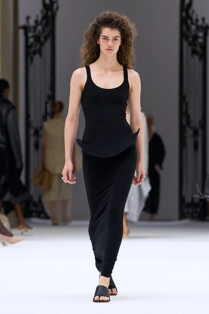 Sportmax Spring 2027 runway model wearing the grey fitted dress with a sculptural curved peplum later worn by Kim Kardashian