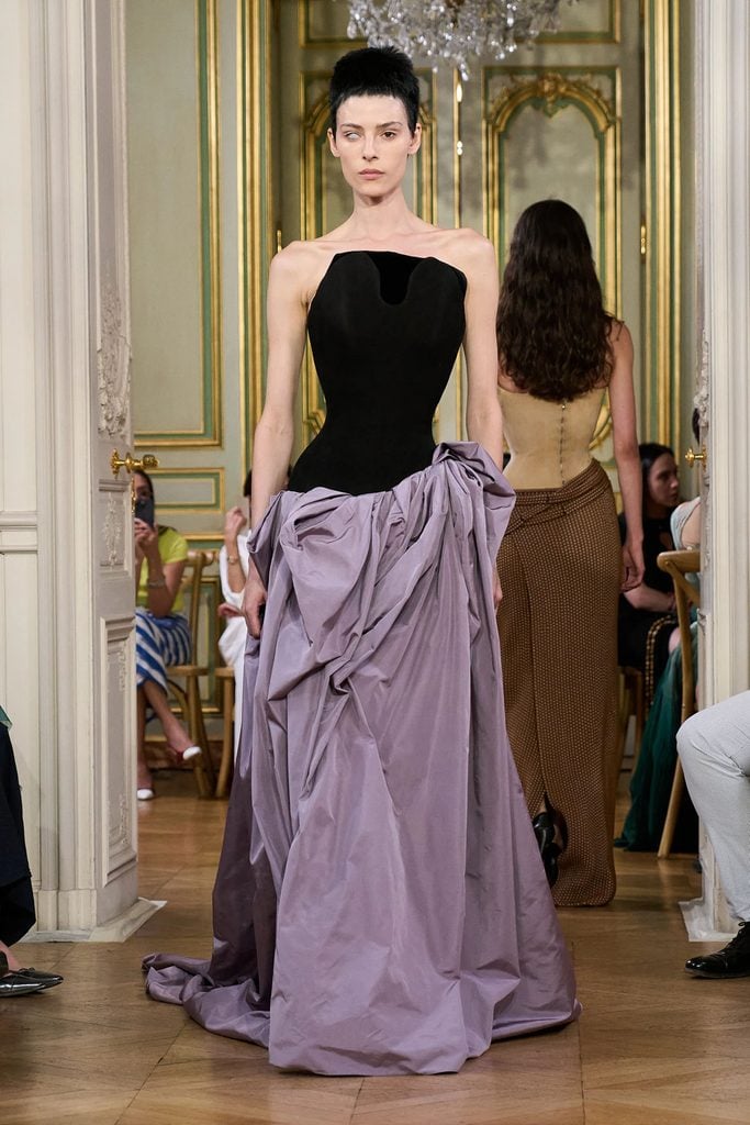 Standing Ground Fall 2026 runway look featuring a sculpted black strapless bodice and draped lavender skirt