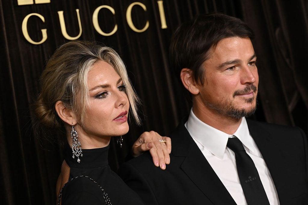 Tamsin Egerton wearing Gucci GG chandelier earrings and a black Gucci gown beside Josh Hartnett in Gucci tailoring at the 2026 Albies in London.