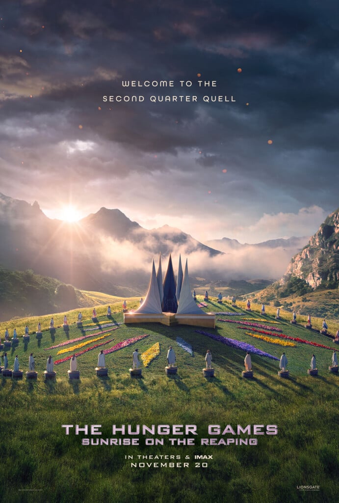 Official The Hunger Games: Sunrise on the Reaping film poster featuring a sunrise over mountains, green meadows and colourful floral arrangements surrounding the Second Quarter Quell arena.