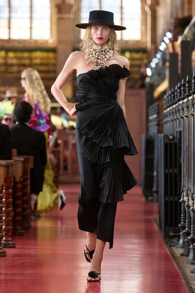 Valentino Spring 2027 runway model wearing the black pleated dress and hat later selected by Naomi Watts.