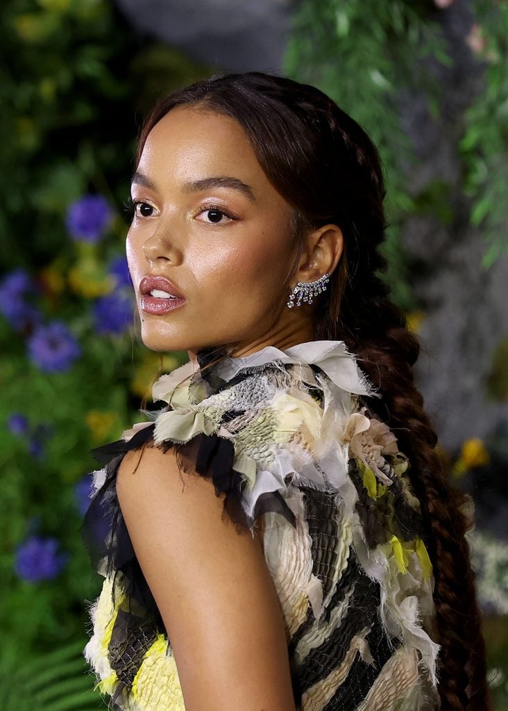 Close-up of Whitney Peak at The Hunger Games London premiere showing her fishtail-braided ponytail, Chanel Tweed Frangé diamond earring and the textured neckline of her Chanel Couture gown.