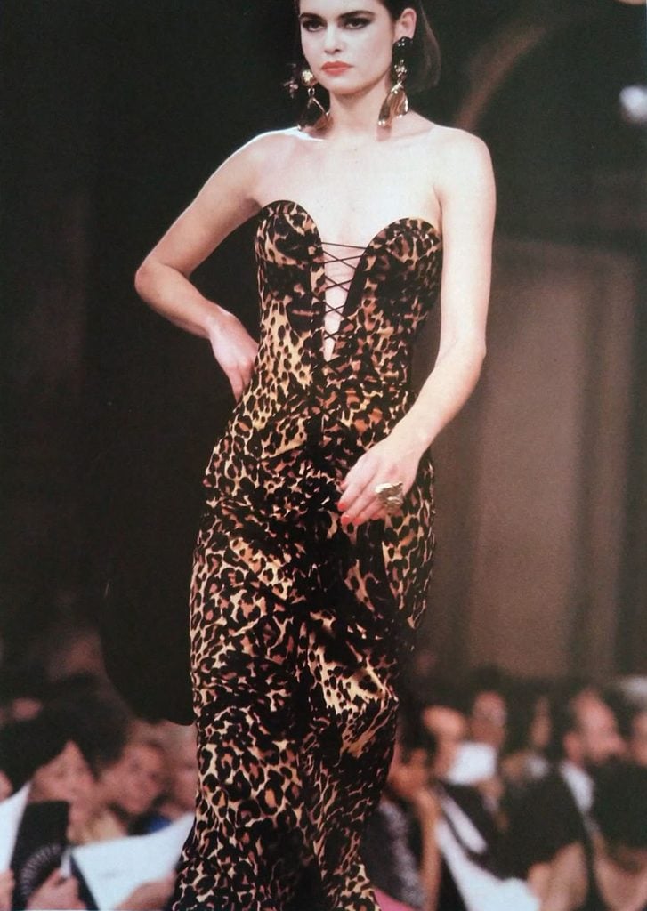 Archival runway photograph of a model wearing the Yves Saint Laurent Golden Tigress leopard-print couture gown with a plunging lace-up bodice.